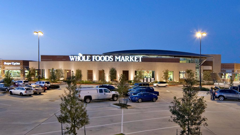 Lake Pointe Village shopping center includes a large anchor store, Whole Foods Market, and shopping center featuring retail stores and restaurants